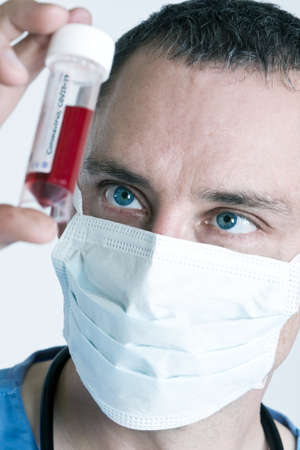 Male doctor wearing face mask with Coronavirus COVID-19 blood sample.の写真素材