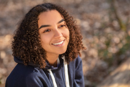 Outdoor portrait of beautiful happy mixed race biracial African American girl teenager female young...