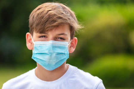 Boy teenager teen male child wearing a face mask outside during the Coronavirus COVID-19 virus  pandemicの写真素材