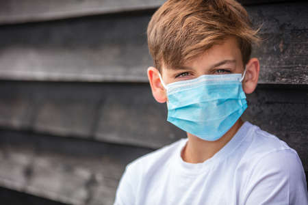 Boy teenager teen male child wearing a face mask outside during the Coronavirus COVID-19 virus  pandemicの写真素材