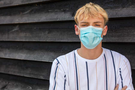 Boy teenager teen male young man wearing a face mask outside during the Coronavirus COVID-19 virus pandemicの写真素材