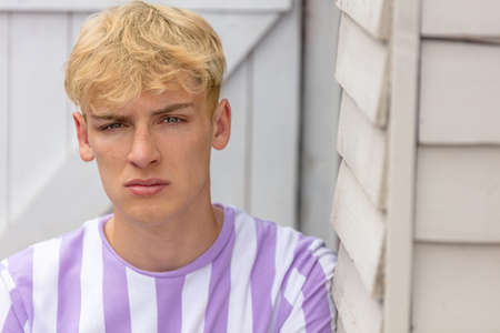 Boy teenager teen blonde male young man outside wearing striped t-shirtの写真素材