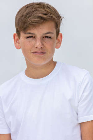 White background studio portrait of a boy teenager teen male child wearing a white t-shirtの写真素材