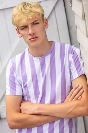 Boy teenager teen blonde male young man outside arms folded and wearing striped t-shirtの写真素材