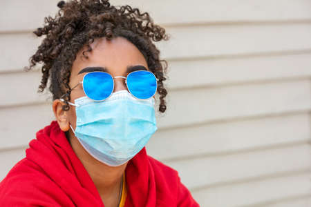 Girl teenager teen mixed race biracial African American female young woman wearing blue sunglasses and face mask in Coronavirus COVID-19 pandemicの写真素材