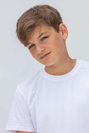 White background studio portrait of a boy teenager teen male child wearing a white t-shirtの写真素材