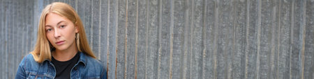 Panoramic portrait of pretty sad, thoughtful or depressed young woman girl teenager female outside in an urban environment panorama web bannerの写真素材