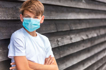 Boy teenager teen male child wearing a face mask outside during the Coronavirus COVID-19 virus  pandemicの写真素材
