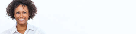 Panorama beautiful happy mixed race African American girl or young woman wearing a white shirt smiling with perfect teeth panoramic web bannerの写真素材