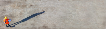 Panoramic overhead aerial view of anonymous construction worker or builder wearing a hi vis jacket,...