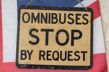 Vintage Retro Omnibus Stop By Request Bus Stop Sign on a Union Jack Flagの写真素材