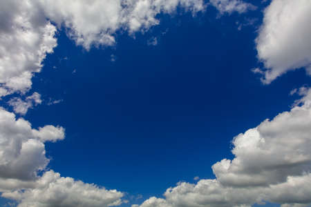 Gap in white clouds showing blue sky on summer dayの写真素材