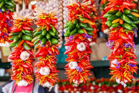 Colorful Fresh Red and Green Chillies, Chili Peppers, Chillis and Garlic Cloves Display Hanging For Sale in a Marketの写真素材