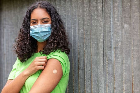 Vaccinated girl teenager teen mixed race biracial African American female young woman wearing face mask.の写真素材