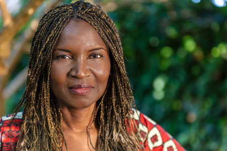Attractive African or African American middle aged woman, female in Africa, with braided hair in braids, wearing traditional clothesの写真素材