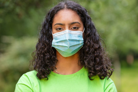 Girl teenager teen mixed race biracial African American female young woman wearing face maskの写真素材