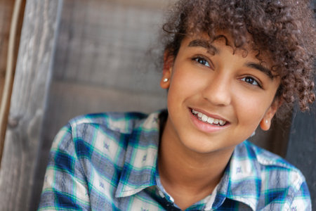 Outdoor portrait of beautiful happy biracial African American girl teenager female young woman smiling with perfect teethの写真素材