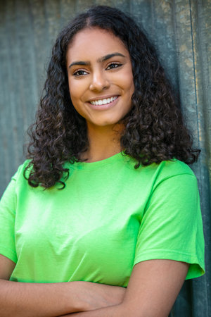 Outdoor portrait of beautiful happy biracial mixed race African American girl teenager female young woman smiling with perfect teeth in an urban city backgroundの写真素材