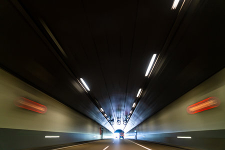 Motion blurred photograph of traffic lorry truck and car on a road in a tunnelの写真素材