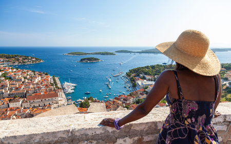African American woman black female tourist overlooking Hvar Town and the island coastline in Croatiaの写真素材