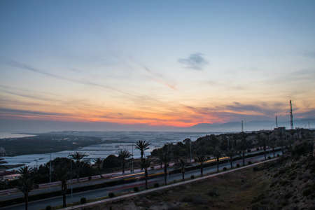 Sunset above the greenhouse and a road with palms, Almeria, Andalusia, Spainの写真素材