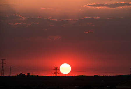 Beautiful red sunset with big sun over the countrysideの写真素材