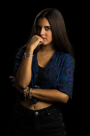 young brunette girl with long straight hair posing, black backgroundの写真素材