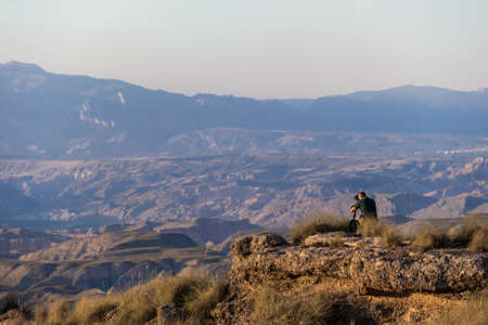 A photographer taking pictures of the Gorafe desert in the light of sunsetの写真素材