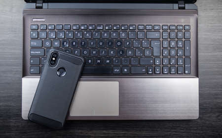 Modern notebook and smartphone copy space. Mobile with dual camera and fingerprint readerの写真素材