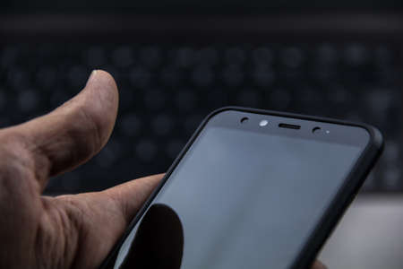 hand of senior person using a modern mobile in a workspaceの写真素材