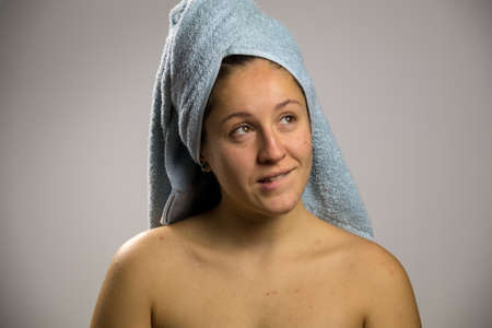 thoughtful and happy girl after shower with two towelsの写真素材