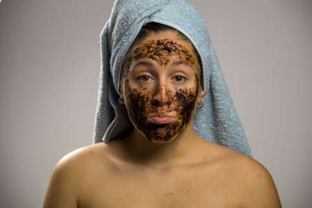 Dubious young woman after shower with two towels. She is looking to cameraの写真素材
