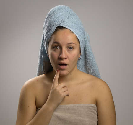 Portrait of unexpected shocked wondered model wrapped in towel with turban on head after shower towel, isolated on white backgroundの写真素材