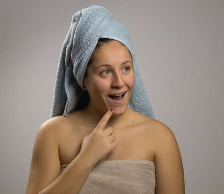thoughtful and happy girl after shower with two towelsの写真素材