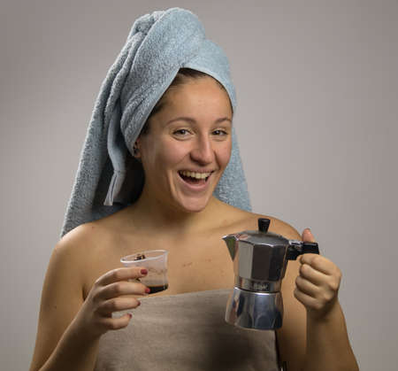 Girl after shower with a towel and happy. Home remedy with coffee anti-spillの写真素材