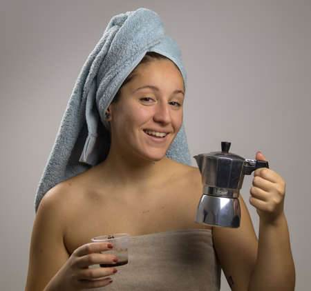 Girl after shower with a towel and smiling. Homemade remedy with coffee for spillの写真素材