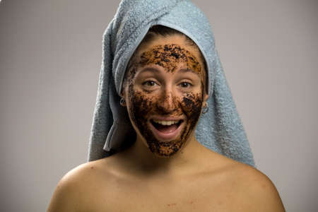 Young woman after shower with a towel and smiling. Homemade remedy with coffee for spillの写真素材