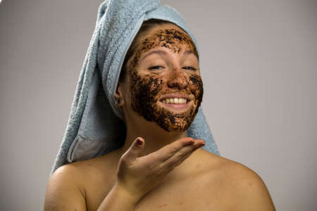 Girl after shower with a towel and smiling. Homemade remedy with coffee for spillの写真素材