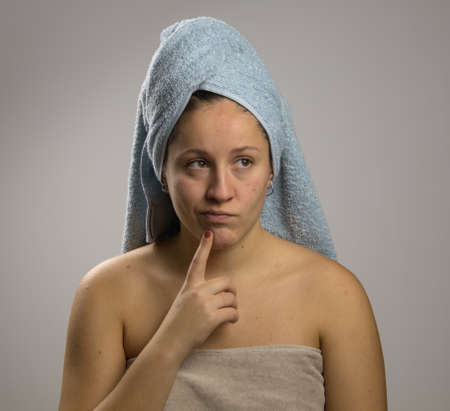 Dubious young woman after shower with two towelsの写真素材