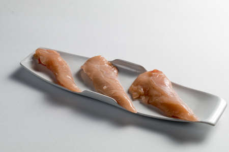 Raw chicken Breasts on a white table. Modern white plateの写真素材