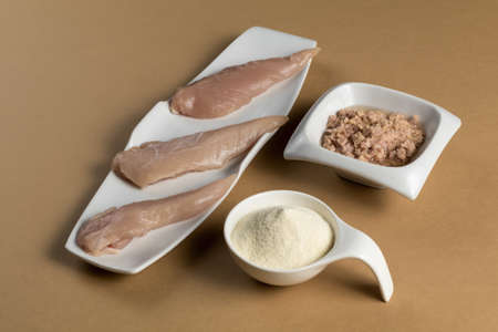 Raw chicken Breasts, tuna in oil and a whey protein scoop vanilla flavor. Sport nutrition. Brown tableの写真素材