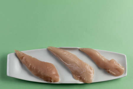 Raw chicken breasts on a green table.Top view. Space Textの写真素材