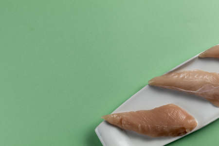 Raw chicken breasts on a green background.Top view. Space Textの写真素材