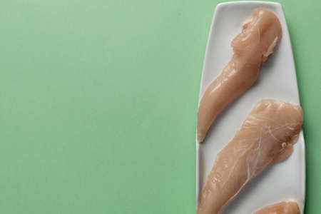 Raw chicken breasts on a green table.Top view. Space Textの写真素材
