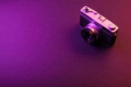 vintage camera isolate on black background and purple light. Space textの写真素材