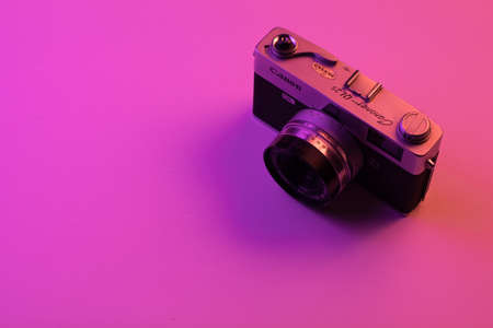 vintage camera isolate on pink background and purple light. Copy spaceの写真素材