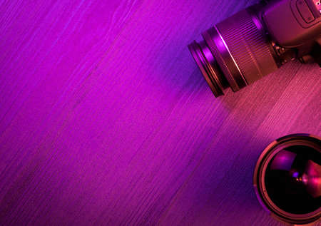 Camera, and fish eye lens. Pink light. Workspace top view. Copy space. Wood backgroundの写真素材