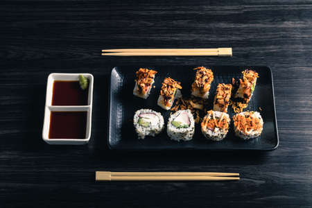Sushi rolls with chopsticks and soy sauce on dark background. Top viewの写真素材