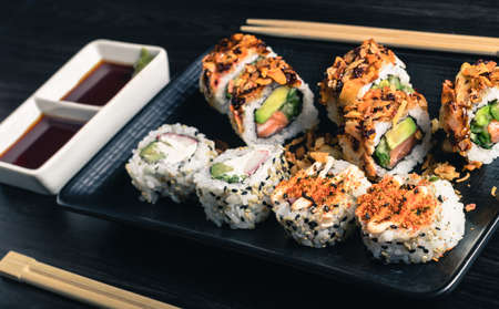 Sushi rolls with chopsticks and soy sauce on dark backgroundの写真素材