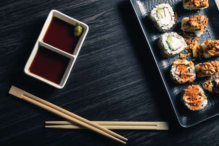 Sushi rolls with chopsticks and soy sauce on dark background. Copy spaceの写真素材